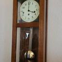 A Matter of Time cover: Ann's pensive face reflected in the glass covering a pendulum clock.